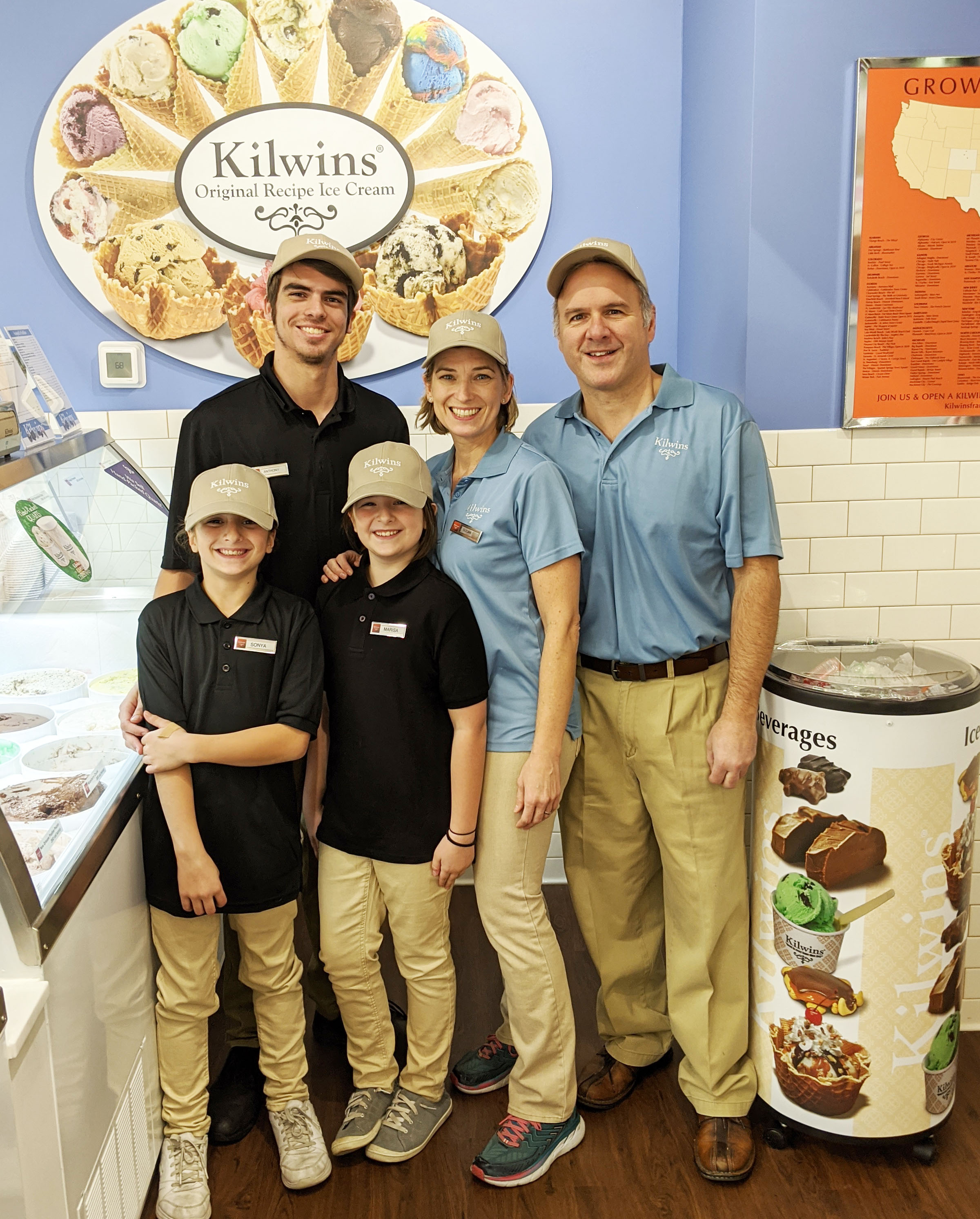 Store owners standing in store with children