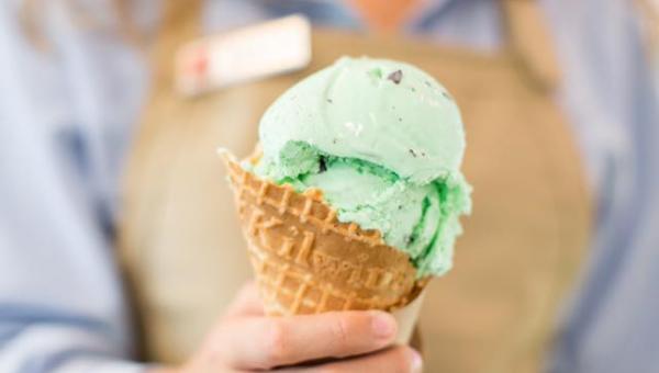 A picture of a woman holding a Kilwins ice cream cone