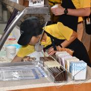 A picture of an employee dipping  Ice cream in Downtown San Antonio 