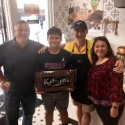 Picture of a family holding a 10lb Kilwins Heritage Chocolate bar 